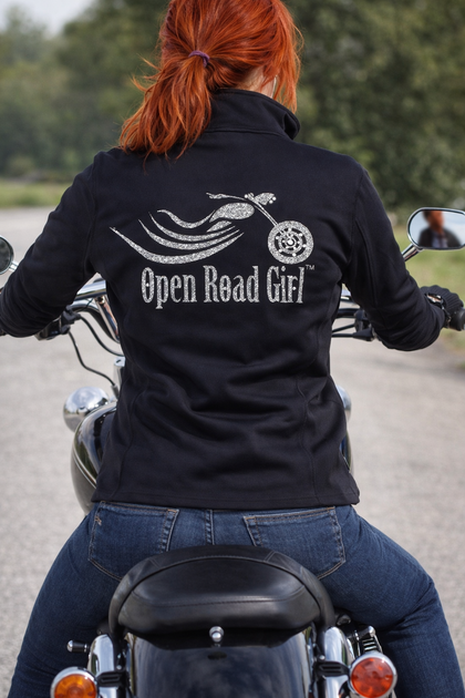 Woman wearing motorcycle jacket while riding – Open Road Girl women’s biker apparel
